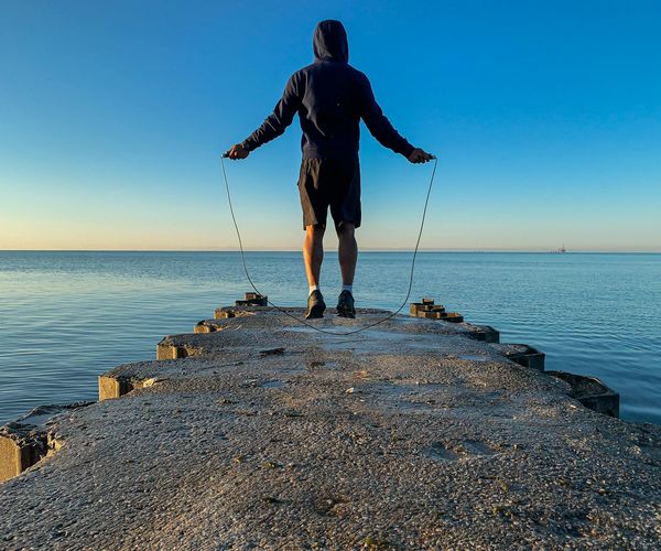 Silhouette of a man stretching against a sunrise, symbolizing energy and well-being.